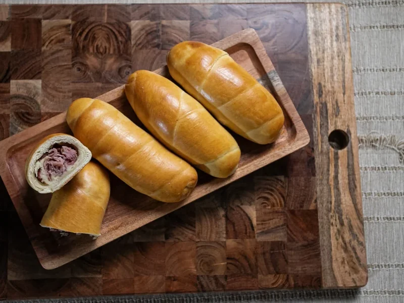 Cachitos completos y uno cortado para mostrar su relleno de jamón